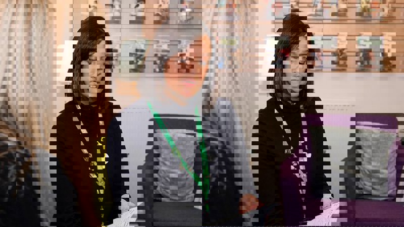 Staff browsing a Macmillan cancer leaflet with a customer. Other leaflets are set out on display in the background.